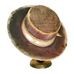 A vintage wide-brimmed hat with a dark brown and beige patterned brim, a burgundy crown, and a patterned band, displayed on a small round stand against a white background.