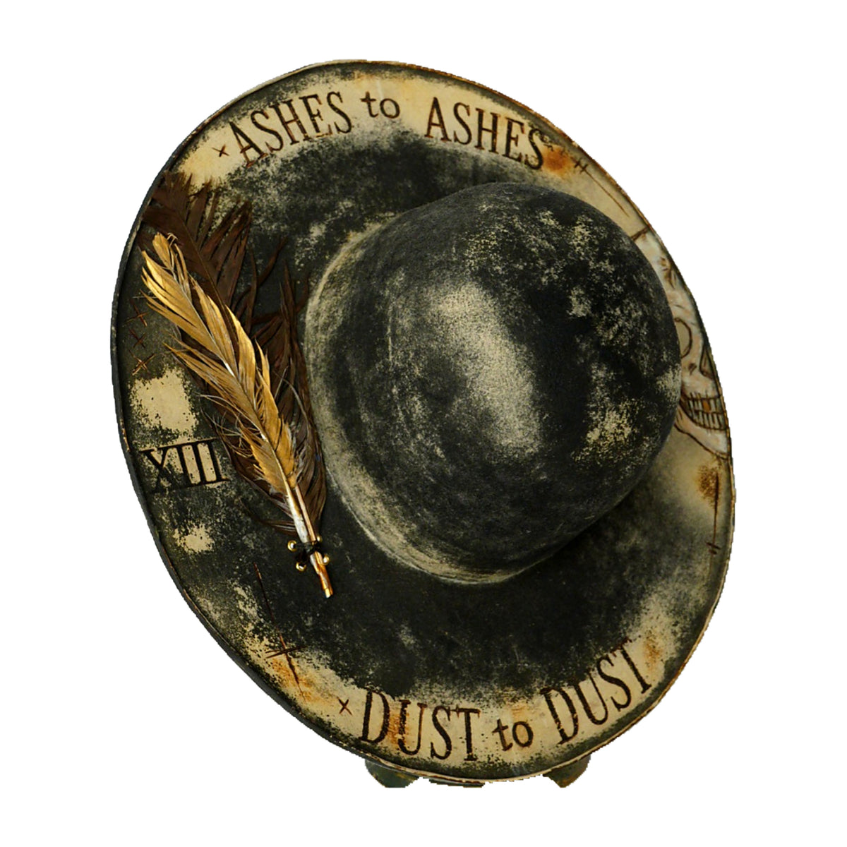 A  distressed black hat, with the words 'ASHES to ASHES' at the top and 'DUST to DUST' at the bottom, plus a feather accent on a white background.